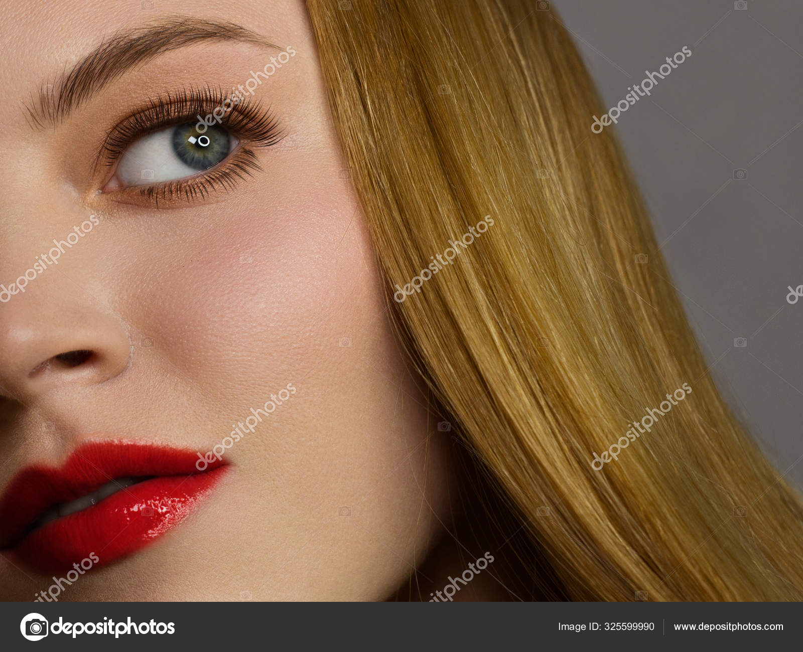 Half of the face of a beautiful redhead with freckles and long red