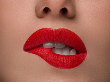 Yakın plan Güzel Portre Modeli Büyük Seksi Dudaklar, Ağız Açık, Beyaz Diş Alt Dudağını Isırdı, Baştan Çıkarıcı Dudaklar Kırmızısı. Kusursuz Tombul Dudaklar 'ın makro görüntüsü. Güzel kadın dudağını tutkuyla ısırdı, beyaz dişli.