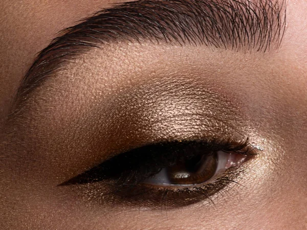 Makro snímek. Detail krásy ženské oko. Sexy kouřové oči make-up s hnědou eyeshadows. Dokonalý silný tvar obočí. Líčení a kosmetika — Stock fotografie
