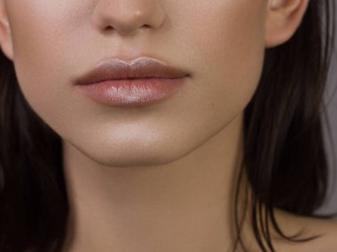 Cinsel dolgun dudaklar. Dudak parlatıcısı ve kadın derisi. Ağız kapalı. Dudaklarda ve kozmetolojide artış. Doğal dudaklar. Açık gözlerle harika bir yaz havası. Moda mücevherleri. Pembe dudak parlatıcısı