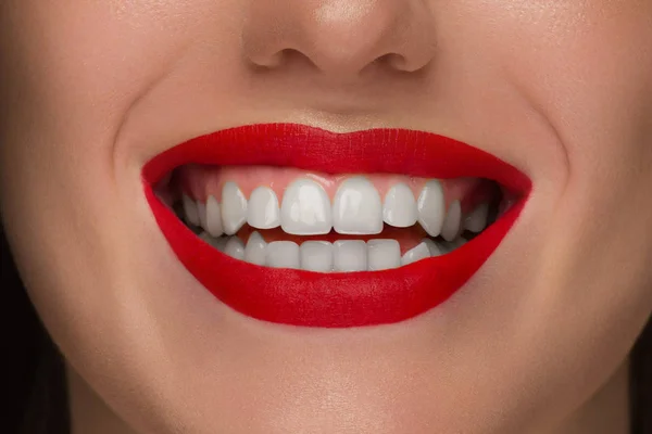 Ritratto ravvicinato della parte inferiore del volto di una bella donna con un sorriso bianco come la neve. Tocco e cura della pelle. Rossetto rosso scarlatto sulle labbra. Sorriso bianco con denti bianchi, odontoiatria — Foto Stock