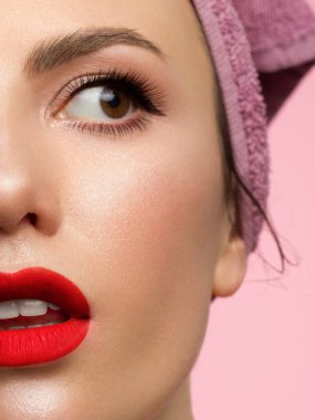 Mükemmel ciltli yarım yüzlü kız. Kadın şaşkınlıkla kameraya bakar, ağzını açar. Gençlik ve cilt bakımı konsepti. Ekstra uzun kirpikler, göz kalemi ve kırmızı rujlu seksi dolgun dudaklar.