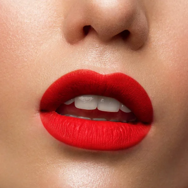 Retrato de cerca de la parte inferior de la cara de una hermosa mujer con una sonrisa blanca como la nieve. Cuidado del tacto y la piel. Lápiz labial rojo escarlata en los labios. Sonrisa blanca con dientes blancos, odontología — Foto de Stock