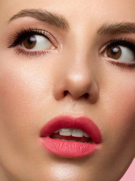 Half gezicht Meisje met een perfecte schone huid. De vrouw kijkt verbaasd naar de camera en doet haar mond open. Jeugd en huidverzorging concept. Extra lange wimpers, eyeliner en sexy gezwollen lippen met roze lippenstift — Stockfoto