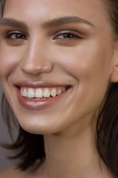 Gros plan portrait de la propreté du visage d'une belle femme aux yeux fumés noir foncé maquillage, lèvres pleines naturelles. Modèle sexy avec peau propre et brillante, visage propre, longs cheveux bouclés. sourire blanc neige — Photo