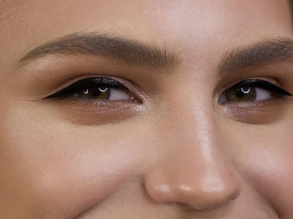 Zbliżenie portret czystość twarzy pięknej kobiety z ciemnoczarnym liniowej makijażu oczu. Seksowny model z czystą, błyszczącą skórą, czystą twarzą, gęstymi brwiami i niezwykle długimi rzęsami — Zdjęcie stockowe