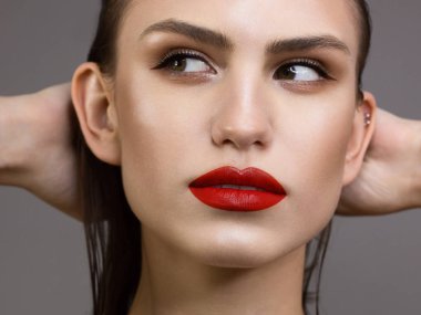 Koyu siyah dumanlı göz makyajı, doğal dolgun dudakları ve son derece uzun kirpikleri olan güzel bir kadının güzel portresi. Uzun kıvırcık saçlı bir model. Göz kalemi ve kalın kaşlar.