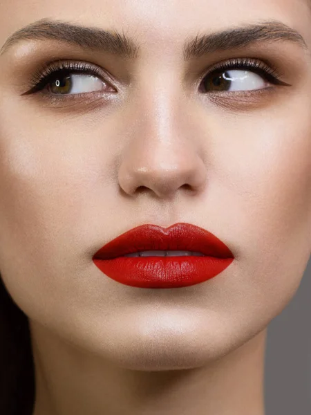 Close-up beauty portrait of the face of a beautiful woman with dark black smoky eye makeup, natural full lips and extremely long eyelashes. Model with wet long curly hair. eyeliner and thick eyebrows — Stock Photo, Image