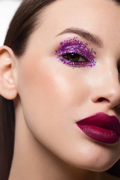 Close-up van de schoonheid van de helft van een vrouw gezicht met creatieve modieuze make-up van sparkles. Zwarte eyeliner en lange wimpers decoreren hazelaar ogen en lippen aan. Well-groomed huid na spa — Stockfoto