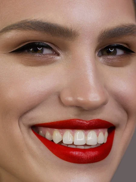 Szoros portré a tisztaság az arc egy gyönyörű nő szemceruza, piros puffadt ajkak. Egy szexi modell tiszta fényes bőrrel, vastag szemöldökkel és nagyon hosszú szempillákkal. mosoly fehér fogakkal — Stock Fotó