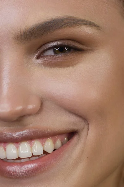 Μισή όμορφη γυναίκα portriet χαμογελώντας στην κάμερα με ένα χιόνι-λευκό ομαλή. Όμορφο φυσικό μακιγιάζ, πρησμένα χείλη, απαλά και πυκνά φρύδια, εξαιρετικά μακριές βλεφαρίδες. Καθαρίστε φρέσκο δέρμα — Φωτογραφία Αρχείου