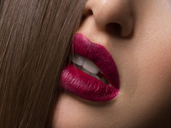 Primo piano di labbra femminili sexy con lucidalabbra marsala e capelli. La pelle pulita e un contorno di labbro chiaro sono delineati da rossetto alla moda. Denti bianchi e bellezza sorriso per la stamotologia, spa o cosmetologia — Foto Stock