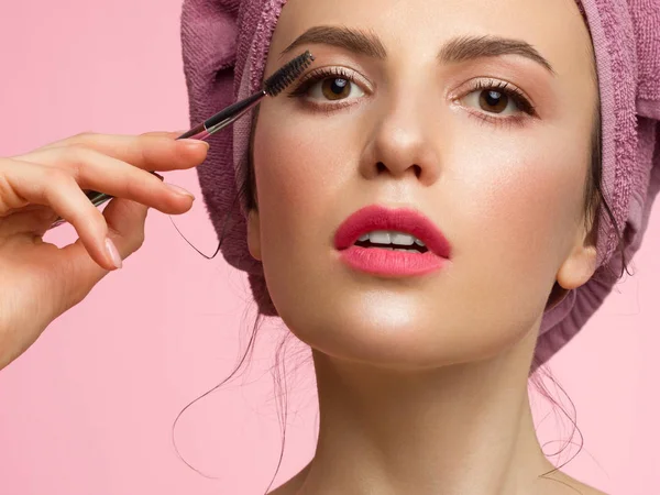 Retrato eslavo feminino de uma jovem com olhos castanhos e sobrancelhas castanhas claras foto close-up de belo o rosto fazendo pestanas de maquiagem com rímel, beleza natural. Mulher com toalha na cabeça — Fotografia de Stock