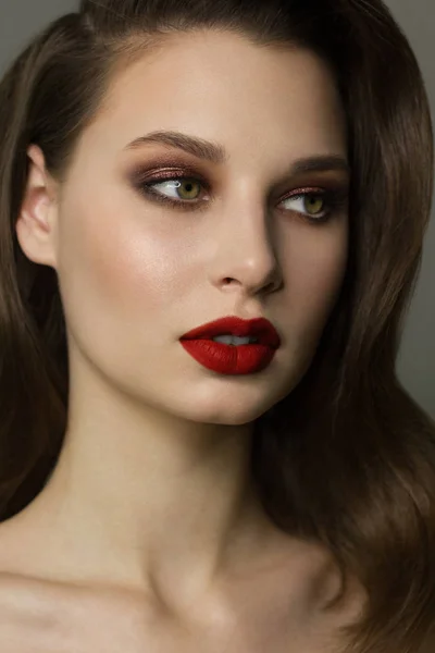 Gros plan portrait de la propreté du visage d'une belle femme aux yeux fumés noir foncé maquillage, lèvres rouges pleines. Modèle sexy avec peau propre et brillante, visage propre, longs cheveux bouclés. image glamour — Photo