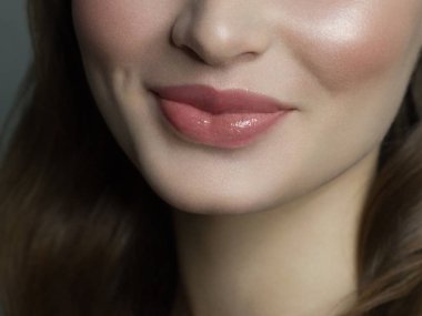 Close-up happy female smile with healthy white teeth, natural lips make-up. Cosmetology, dentistry and beauty care. Macro of woman's smiling mouth