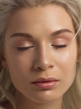 Temiz ciltli ve doğal kozmetik ürünleri olan güzel bir kadın. Güzel, ekstrem kirpik ve bakımlı bir kızın dolgun dudakları güzellik salonunda spa prosedürleri ve enjeksiyonlar gösteriyor. Sarı saç.