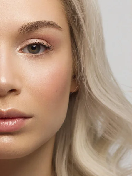 Nahaufnahme einer halben Schönheit mit sauberer Haut und Naturkosmetik. Schöne extreme Wimpern und volle Lippen gepflegter Mädchen demonstrieren Wellness-Verfahren, Injektionen in einem Schönheitssalon. Blonde Haare — Stockfoto