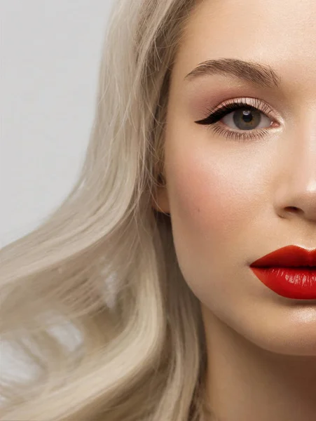 Close-up beauty of a half female face with creative fashion evening make-up. Black arrows on the eyes and extremely long eyelashes, on plump lips matte scarlet lip color. Well-groomed skin after spa