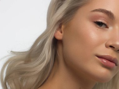 Temiz ciltli ve doğal kozmetik ürünleri olan yarı güzel bir kadın. Güzel, ekstrem kirpik ve bakımlı bir kızın dolgun dudakları güzellik salonunda spa prosedürleri, enjeksiyonlar gösteriyor. Sarı saç.