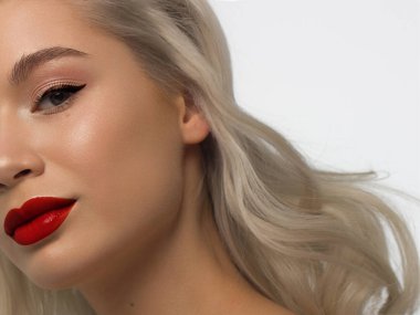 Yaratıcı moda gecesi makyajlı, yarı kadın yüzünün yakın plan güzelliği. Gözlerde siyah oklar ve son derece uzun kirpiklerde, dolgun dudaklarda kırmızı dudak rengi. Kaplıcadan sonra iyi bakımlı cilt