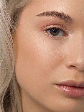 Temiz ciltli ve doğal kozmetik ürünleri olan yarı güzel bir kadın. Güzel, ekstrem kirpik ve bakımlı bir kızın dolgun dudakları güzellik salonunda spa prosedürleri, enjeksiyonlar gösteriyor. Sarı saç.