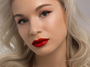 Düz saçlı bir kadının yakın plan portresi. Sevimli genç sarışın kız. Kırmızı ruj, şeffaf temiz ten. Spa salonunda ya da kozmetolojide cilt bakımı doğal kozmetik ürünleri.