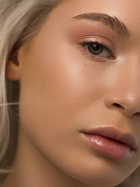 Половина портрета красоты с красивым модным вечерним макияжем, натуральными глазами и чрезвычайно длинными ресницами. Обнажённая помада на губах. Косметология и спа уход за кожей лица
