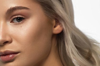 Temiz ciltli ve doğal kozmetik ürünleri olan yarı güzel bir kadın. Güzel, ekstrem kirpik ve bakımlı bir kızın dolgun dudakları güzellik salonunda spa prosedürleri, enjeksiyonlar gösteriyor. Sarı saç.