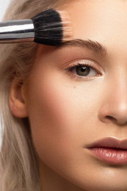 Temiz ciltli ve doğal kozmetik ürünleri olan yarı güzel bir kadın. Güzel, ekstrem kirpik ve bakımlı bir kızın dolgun dudakları güzellik salonunda spa prosedürleri, enjeksiyonlar gösteriyor. Sarı saç.