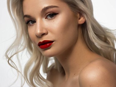 Düz saçlı bir kadının yakın plan portresi. Sevimli genç sarışın kız. Kırmızı ruj, şeffaf temiz ten. Spa salonunda ya da kozmetolojide cilt bakımı doğal kozmetik ürünleri.