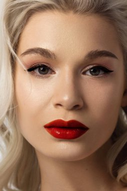 Düz saçlı bir kadının yakın plan portresi. Sevimli genç sarışın kız. Doğal ruj, şeffaf temiz ten. Spa salonunda ya da kozmetolojide cilt bakımı doğal kozmetik ürünleri.