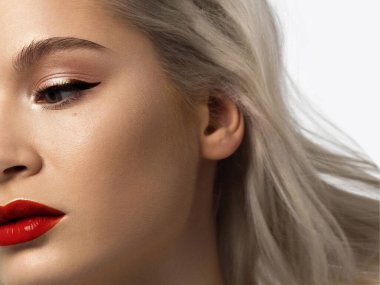 Yaratıcı moda gecesi makyajlı, yarı kadın yüzünün yakın plan güzelliği. Gözlerde siyah oklar ve son derece uzun kirpiklerde, dolgun dudaklarda kırmızı dudak rengi. Kaplıcadan sonra iyi bakımlı cilt