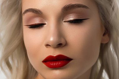 Düz saçlı bir kadının yakın plan portresi. Sevimli genç sarışın kız. Kırmızı ruj, şeffaf temiz ten. Spa salonunda ya da kozmetolojide cilt bakımı doğal kozmetik ürünleri.