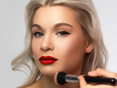 Moda gecesi makyajlı bir kadının yakın plan güzelliği. Gözlerde siyah çizgili ve son derece uzun kirpikleri var. Dudakları dolgun, dudak boyası kırmızı. Kaplıcadan sonra iyi bakımlı cilt. kırmızı ruj