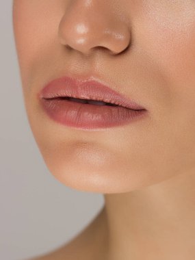 Kozmetik, makyaj ve trendler. Parlak dudak parlatıcısı ve ruj. Doğal dudak makyajlı güzel bir kadın ağzı. Kadın yüzünün güzel bir parçası. Doğal ışıkta kusursuz temiz bir ten.