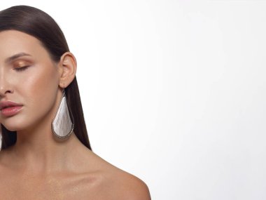 Güzel ciltli, çıplak makyajlı, göz kalemi ve uzun kirpikli, şişkin doğal dudaklı ve beyaz çiçekli bir yüzün yarım portresini kapat. Moda fotoğrafçılığı. Kozmetik ve kaplıca. Baharın tazeliği