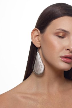 Güzel ciltli, çıplak makyajlı, göz kalemi ve uzun kirpikli, şişkin doğal dudaklı ve beyaz çiçekli bir yüzün yarım portresini kapat. Moda fotoğrafçılığı. Kozmetik ve kaplıca. Baharın tazeliği