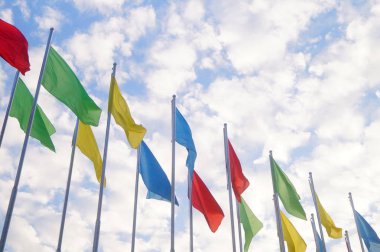 Renkli bayrak beyaz bulutlar, çok güzel ve mavi gökyüzü altında.