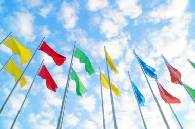 Renkli bayrak beyaz bulutlar, çok güzel ve mavi gökyüzü altında.