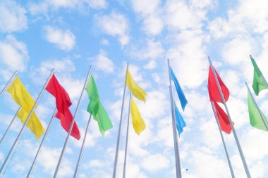 Renkli bayrak beyaz bulutlar, çok güzel ve mavi gökyüzü altında.