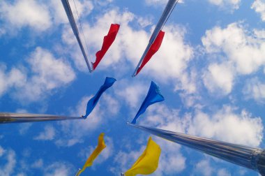 Renkli bayrak beyaz bulutlar, çok güzel ve mavi gökyüzü altında.