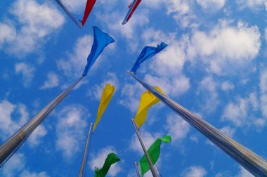 Renkli bayrak beyaz bulutlar, çok güzel ve mavi gökyüzü altında.