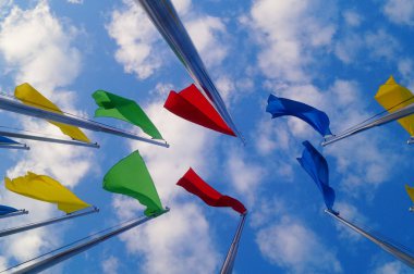 Renkli bayrak beyaz bulutlar, çok güzel ve mavi gökyüzü altında.