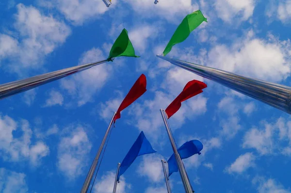 Bandera de colores bajo el cielo azul y nubes blancas, muy hermosa . —  Fotos de Stock