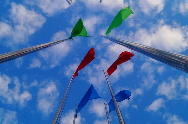 Bandera de colores bajo el cielo azul y nubes blancas, muy hermosa . — Foto de Stock