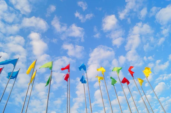 Bunte Fahne unter blauem Himmel und weißen Wolken, sehr schön. — Stockfoto