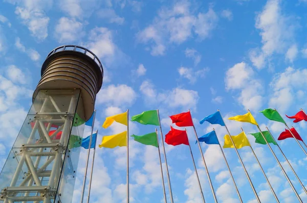 Bandiera colorata sotto il cielo blu e nuvole bianche, molto bella . — Foto Stock