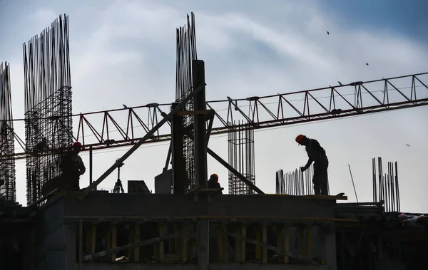 Silueta de personas que trabajan y construyen edificios — Foto de Stock