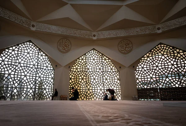 Local people praying inside the modern mosque. Sunlight shines t — Stock Photo, Image