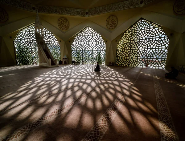 Local people praying inside the modern mosque. Sunlight shines t — Stock Photo, Image